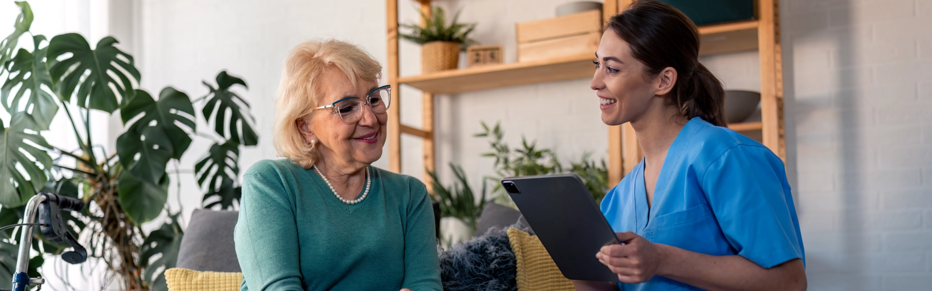 An elderly woman and a female caregiver talking to each other