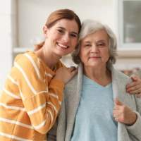 A female hugging an elderly woman