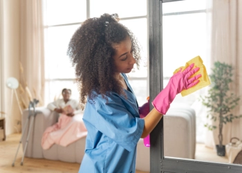 A female caregiver cleaning a glass window