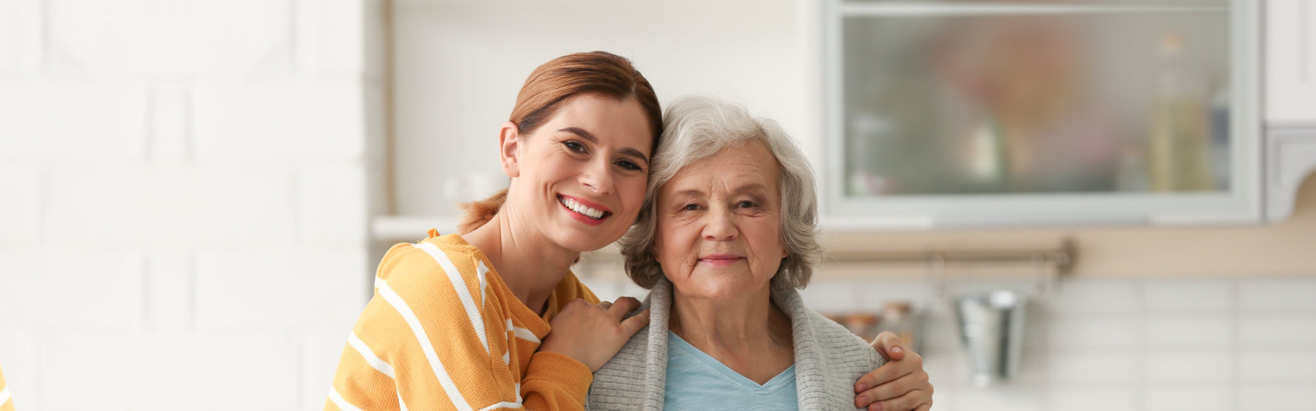 A female hugging an elderly woman